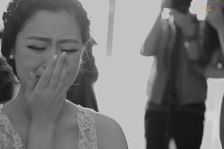 Bride wiping away a tear during her wedding ceremony
