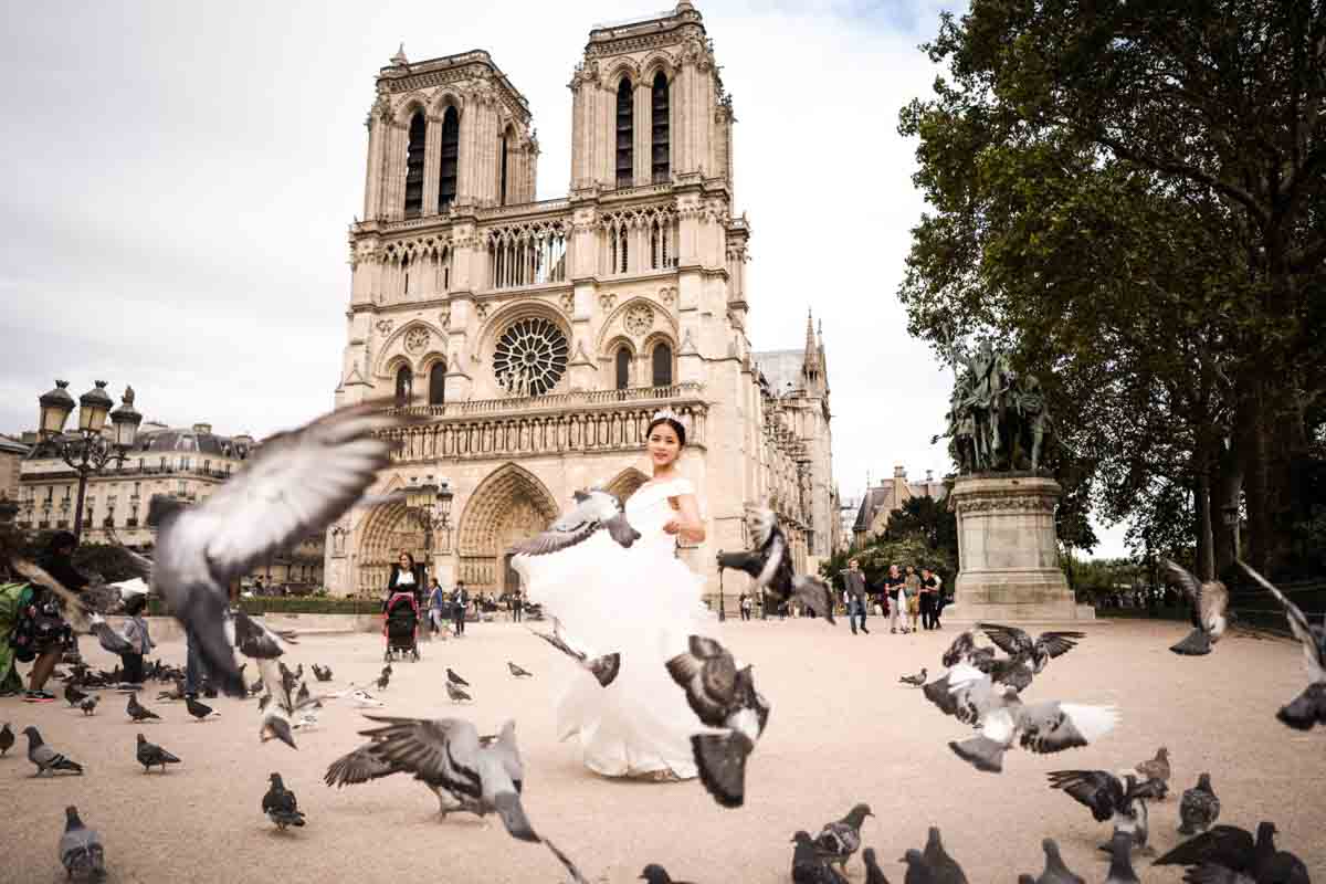 Bride surrounded by flying pigeons near Notre-Dame in Paris